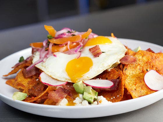 Applewood Smoked Bacon Chilaquiles on a plate with eggs.