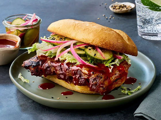Boneless pork ribs in bulgogi sauce on French roll with Asian-inspired slaw, cucumber coins, and gochujang sauce