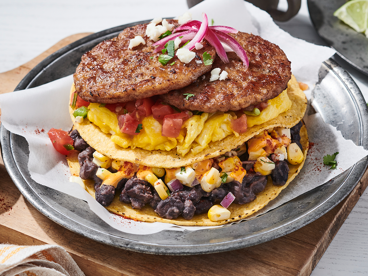 An Elote Breakfast Tostada Stack Featuring Jimmy Dean® Fully Cooked Pork Sausage Patties and Mexican Original® Yellow Corn Round Tortilla Chips.