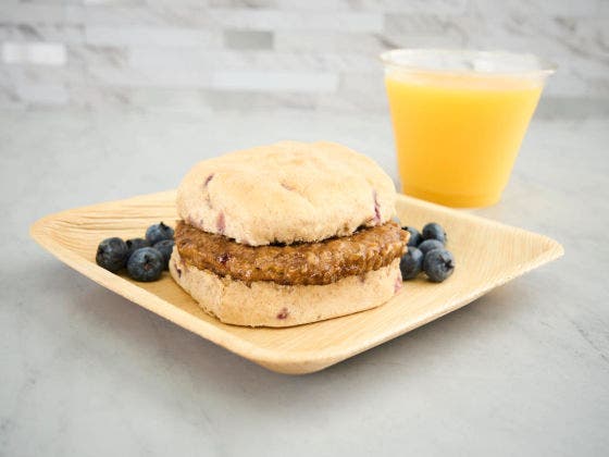 Blueberry Sausage Biscuit on a Plate With Orange Juice.