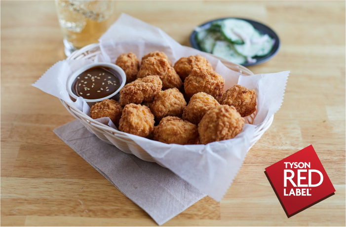 Boneless wings in a basked with red side sauce