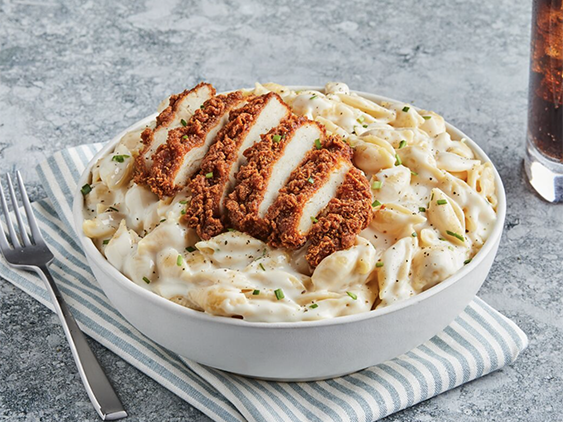 A crispy chicken Filet, sliced, on top of mac n cheese shells.