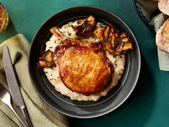 Pan-seared Frenched pork chop steak with risotto and roasted maitake mushrooms