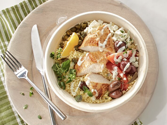 Chicken Breast is sliced and served over couscous, topped with feta cheese, fresh tomato, kalamata olives and capers
