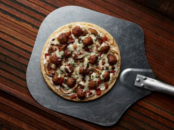 Meatball pizza with Italian meatballs, shredded mozzarella and caramelized onions, sliced mushrooms and parsley. 