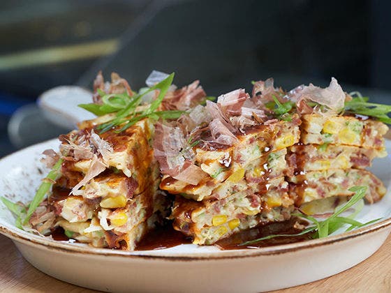 Breakfast Okonomiyaki with garnish on a plate.
