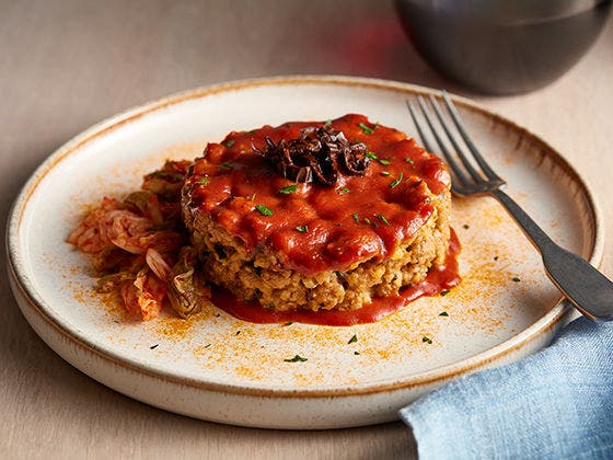 Plated round meatloaf with tomato glaze and fork image