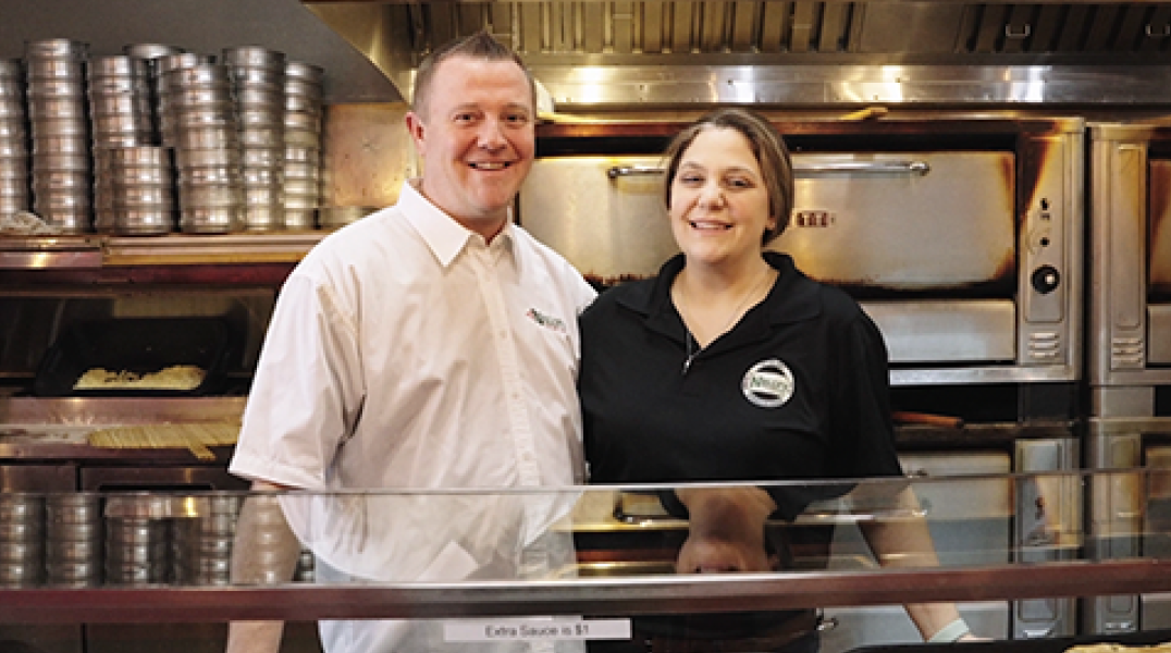 2022 Great Pizza Give Back winners, owners standing in front of their pizza oven